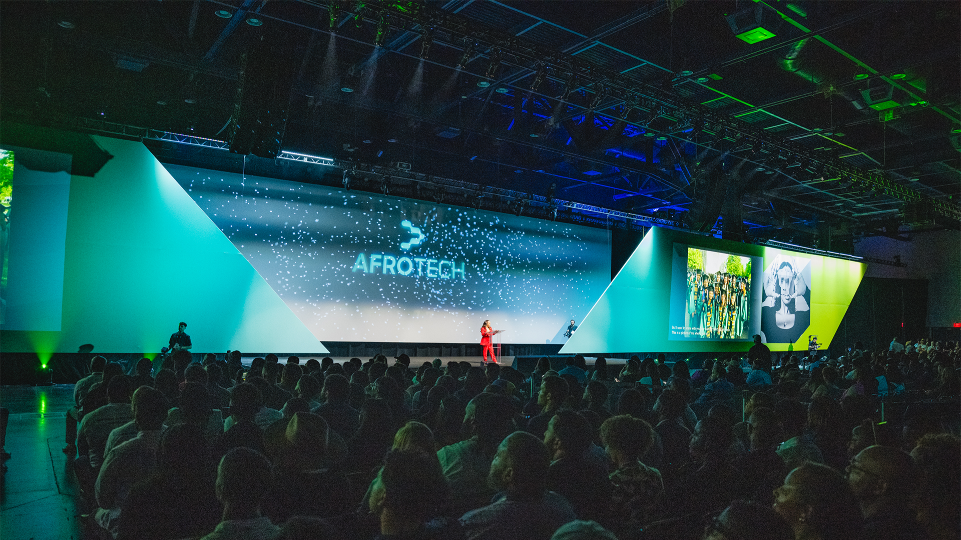 A large conference room filled with attendees facing a stage with the 