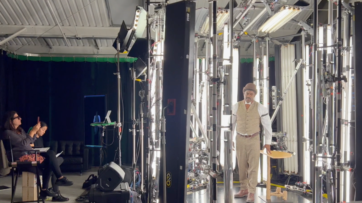 Actor stands inside 360 video set with director nearby.