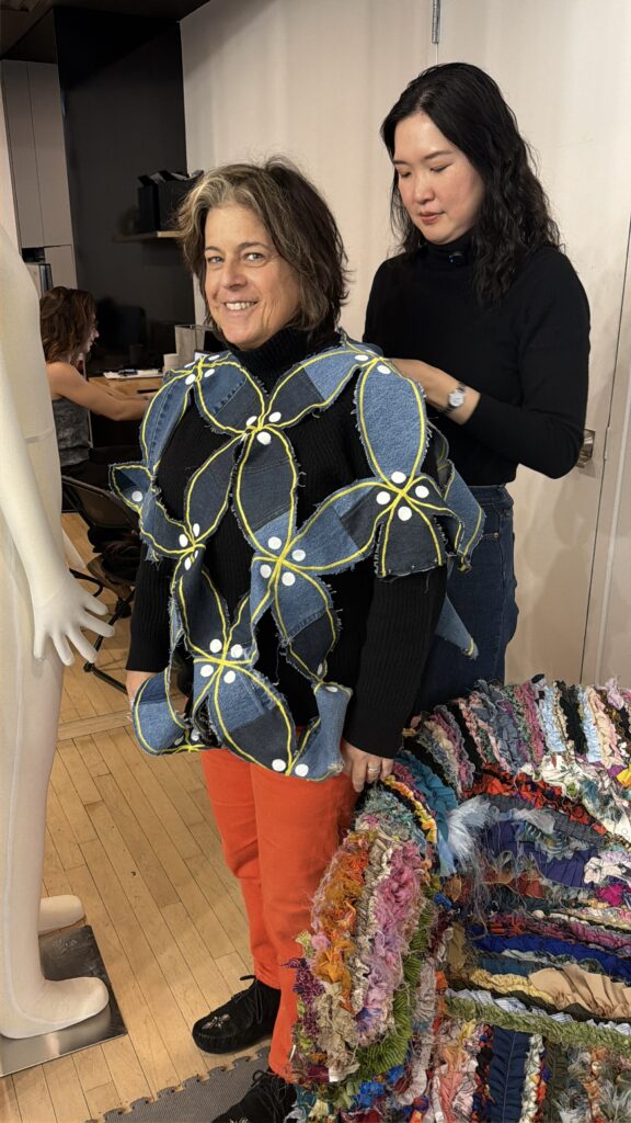 Mira helps Agog's Amy Seidenwurm put on the kuwang top