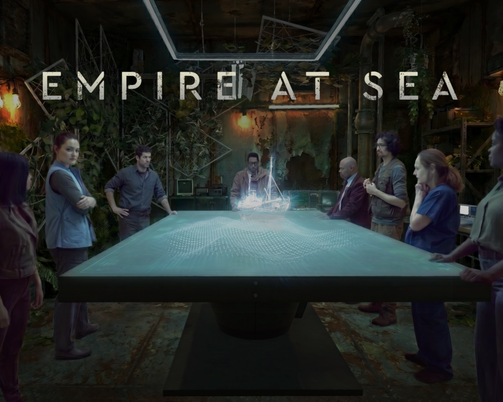 alt="'Empire at Sea' title over seven people gathered around a table projecting a holographic ship, in an overgrown industrial room"